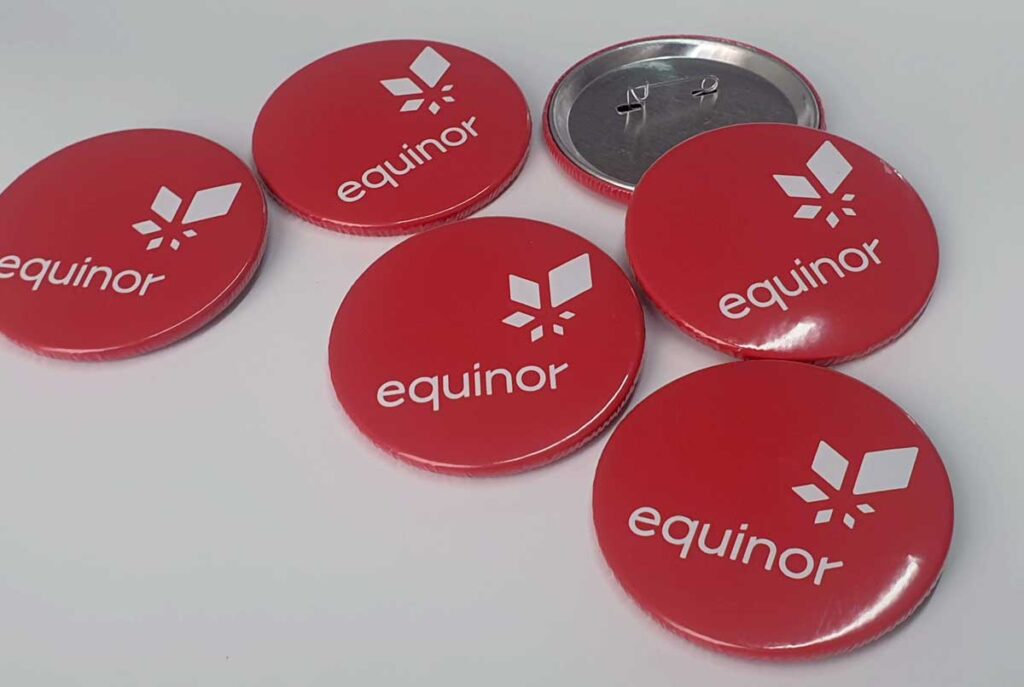 Close do botton metálico com fecho de alfinete e impressão laminada em botton personalizado